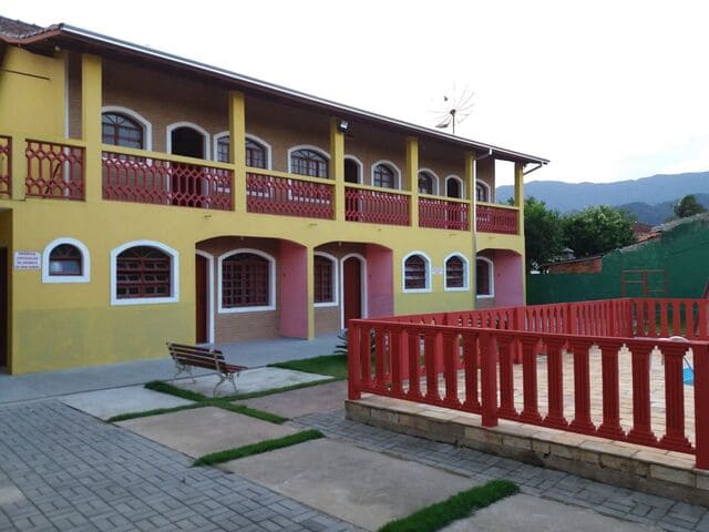 Fachada dos Chalés Bandeiras com varandas e piscina